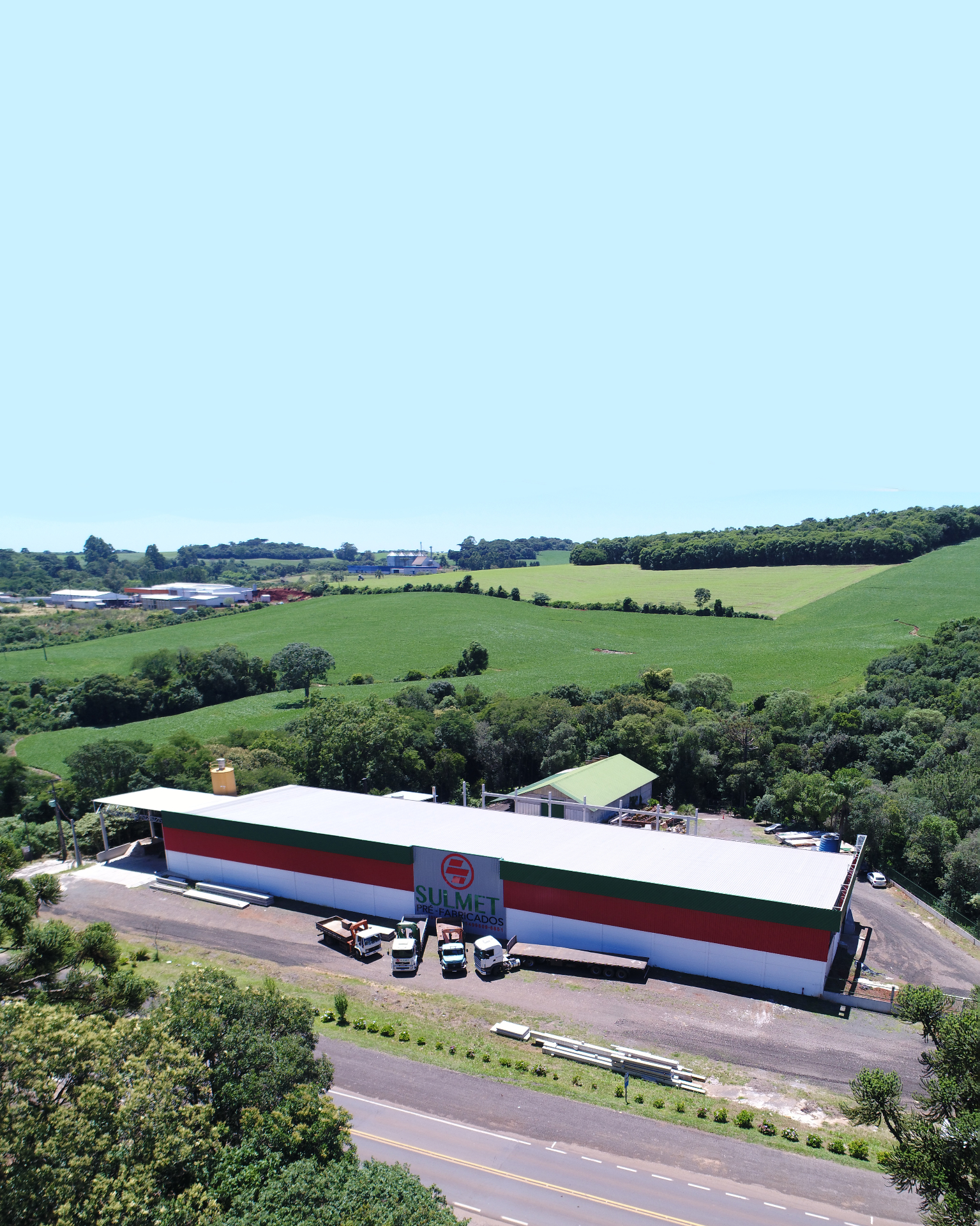 Sede da Sulmet Pré-Fabricados vista de cima, com galpão industrial e estrada